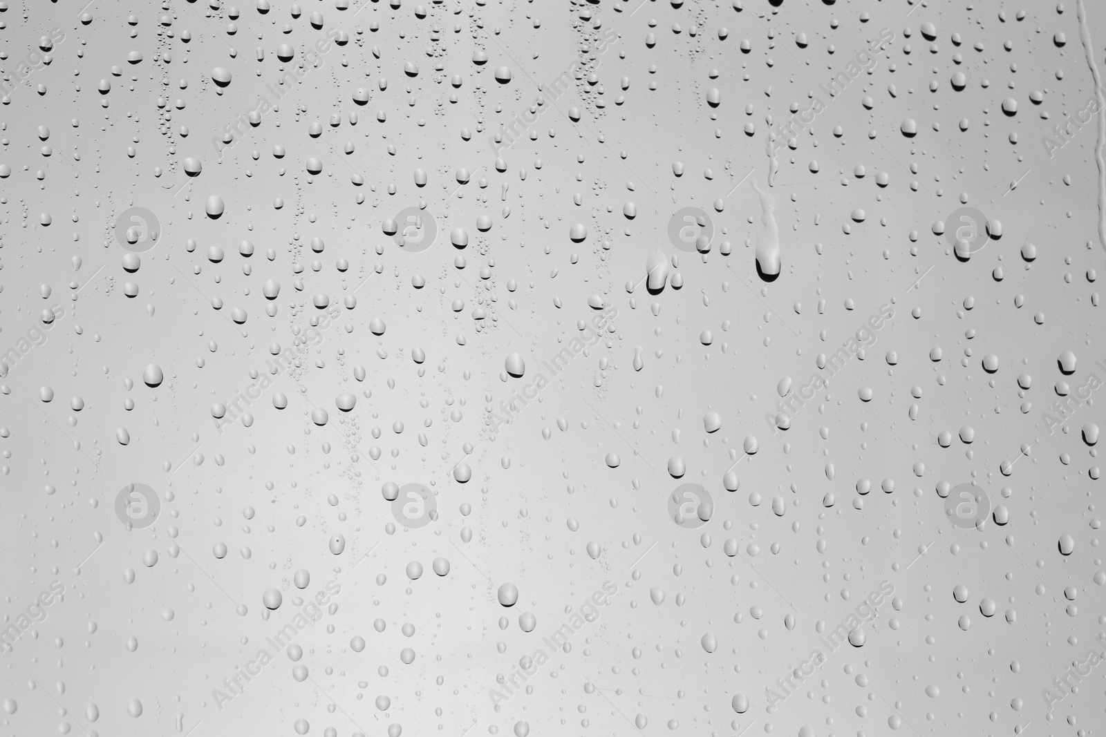 Photo of Water drops on light grey glass surface, top view