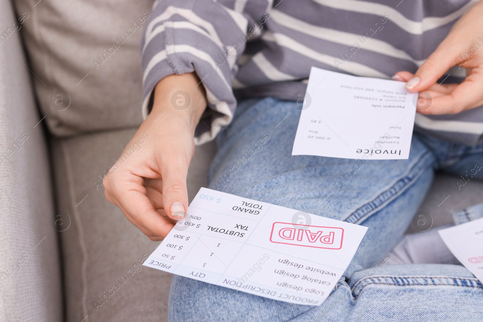 Photo of Paying bills. Woman with different invoices on couch at home, closeup