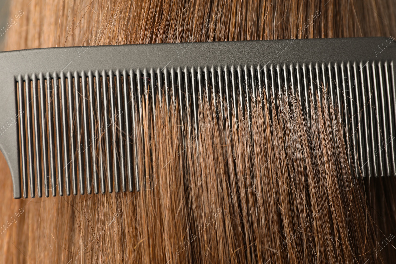 Photo of Brushing hair with plastic comb, closeup view