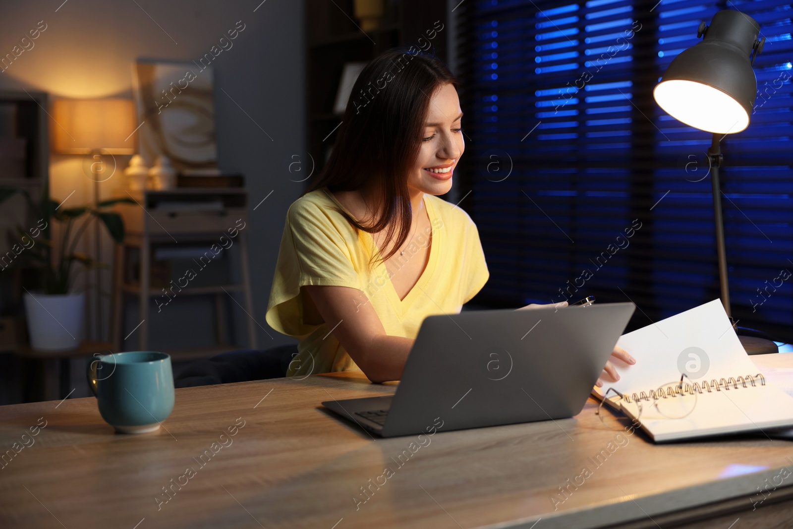 Photo of Woman working on laptop at desk in home office