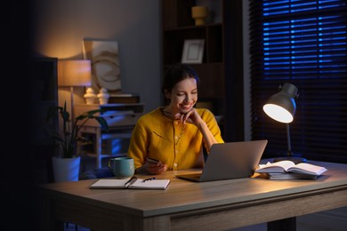 Photo of Woman working on laptop at desk in home office