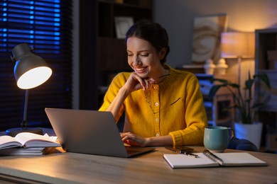 Photo of Woman working on laptop at desk in home office