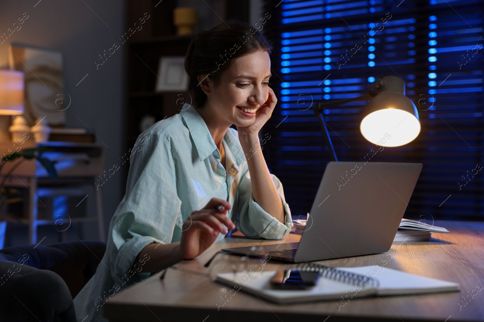 Photo of Woman working on laptop at desk in home office