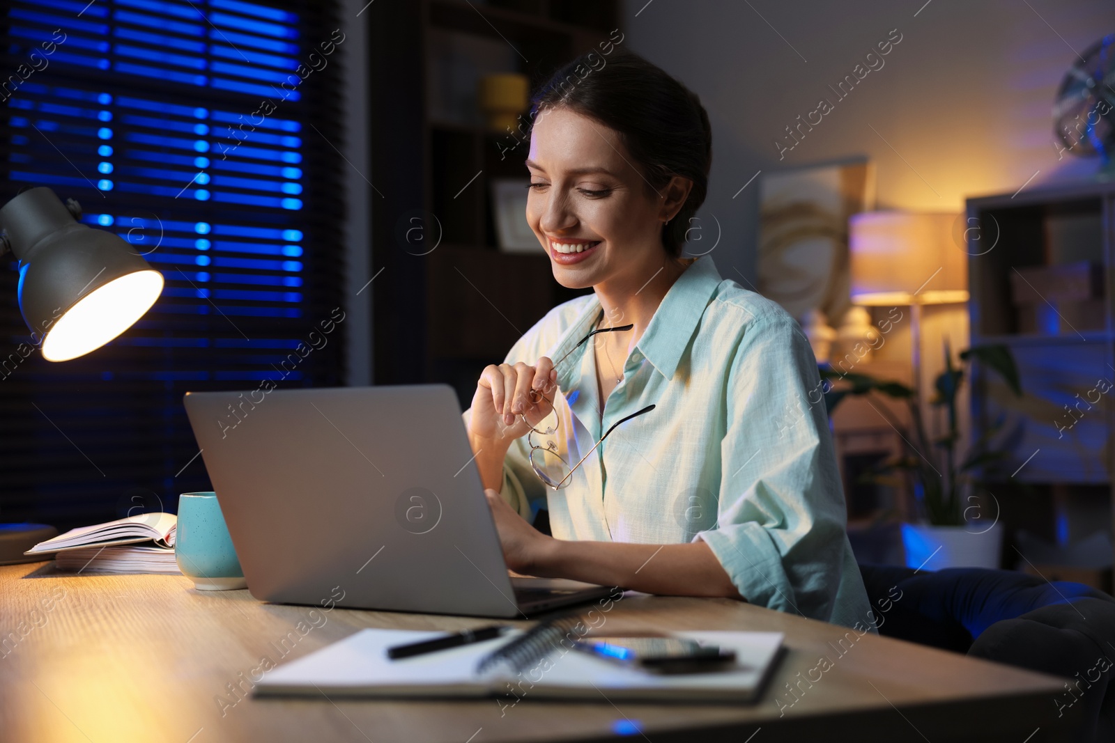 Photo of Woman working on laptop at desk in home office