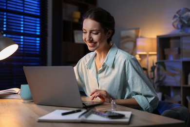 Photo of Woman working on laptop at desk in home office