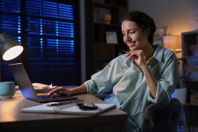 Photo of Woman working on laptop at desk in home office