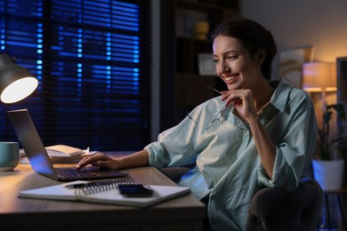 Photo of Woman working on laptop at desk in home office