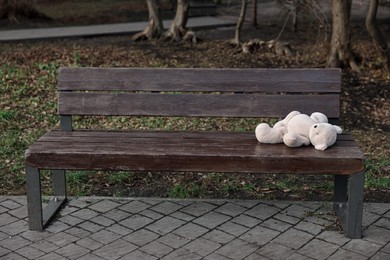 Photo of Lost white teddy bear on wooden bench in park