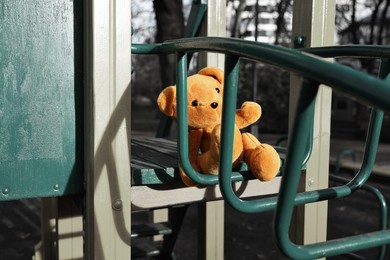 Photo of Lost brown teddy bear on playground outdoors