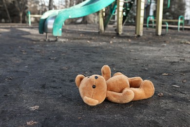 Photo of Lost brown teddy bear on ground outdoors