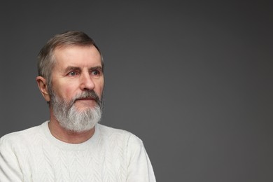 Photo of Portrait of mature man on grey background, space for text