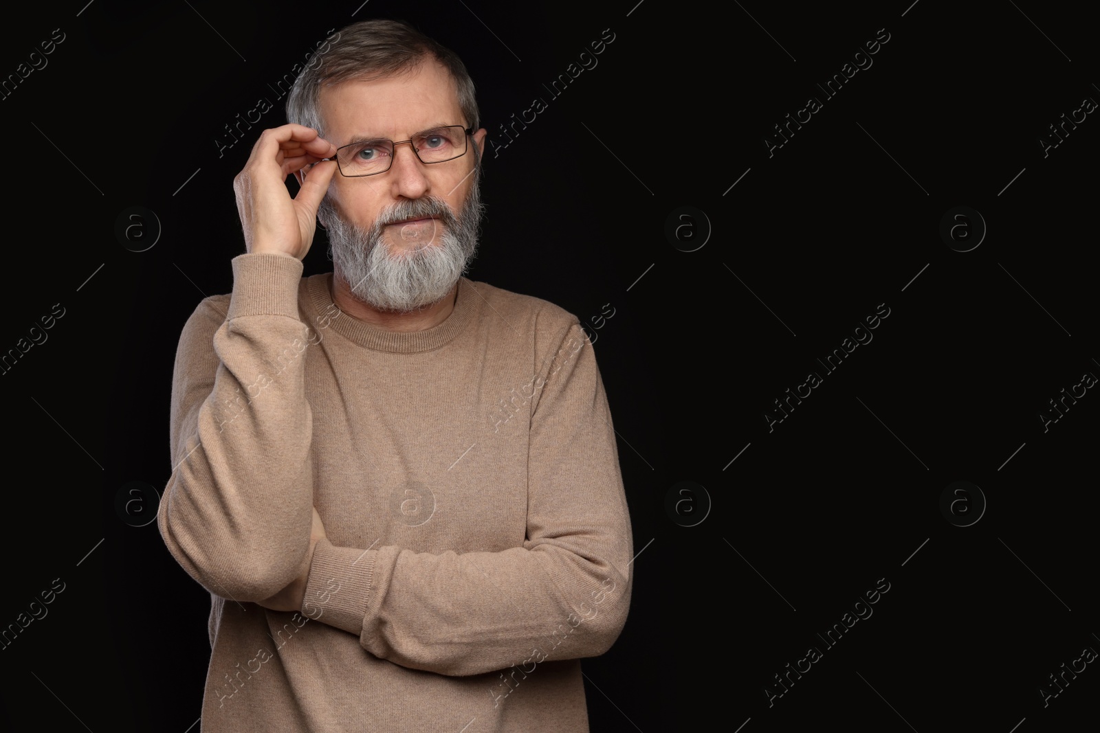 Photo of Portrait of mature man in glasses on black background, space for text