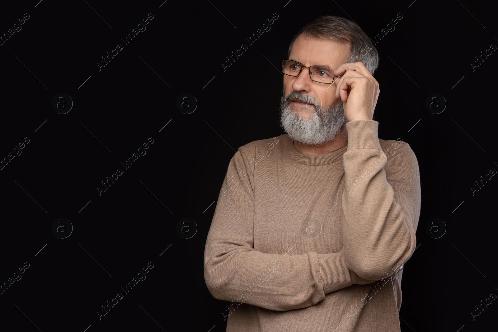 Photo of Portrait of mature man in glasses on black background, space for text