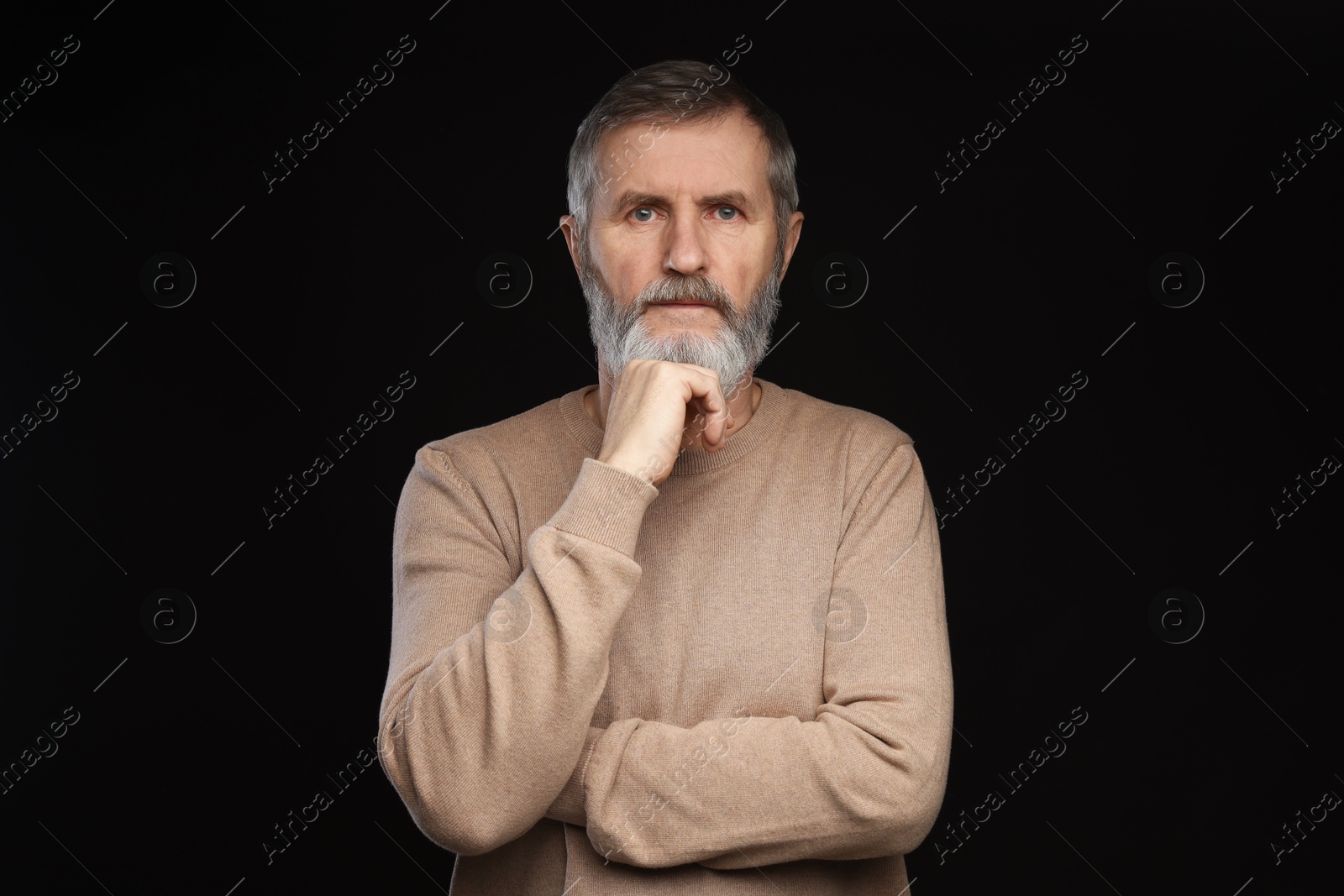 Photo of Portrait of mature man on black background