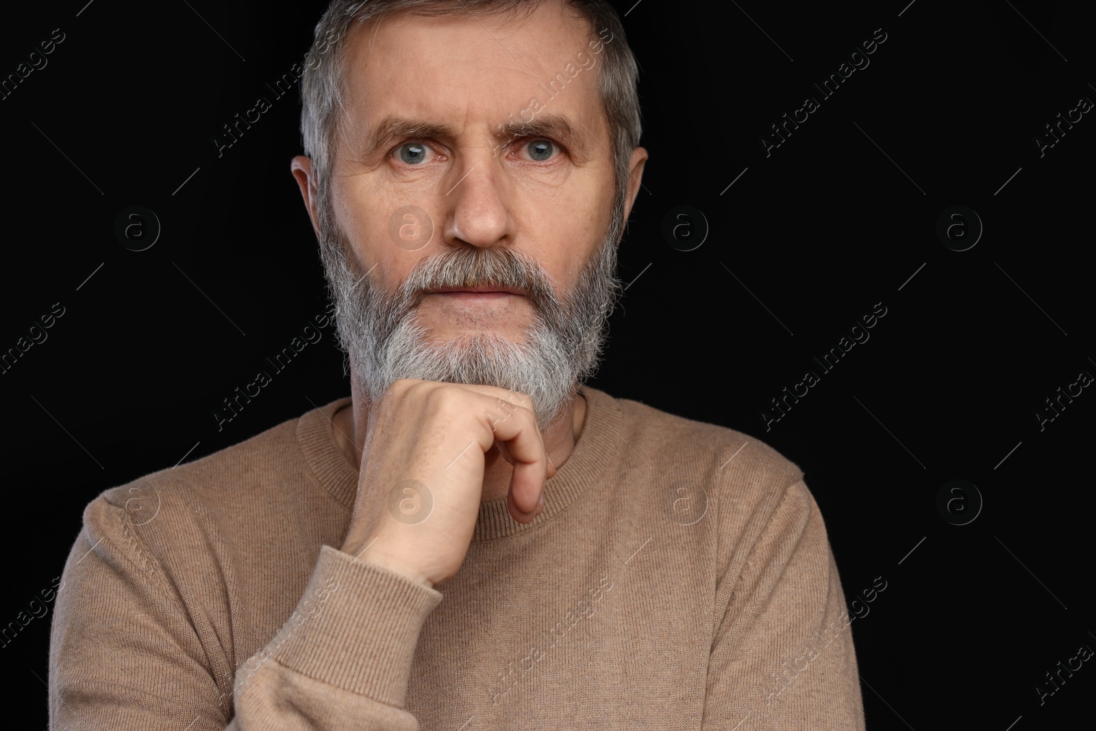 Photo of Portrait of mature man on black background