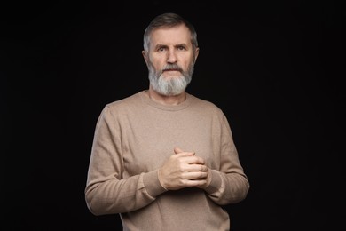 Photo of Portrait of mature man on black background