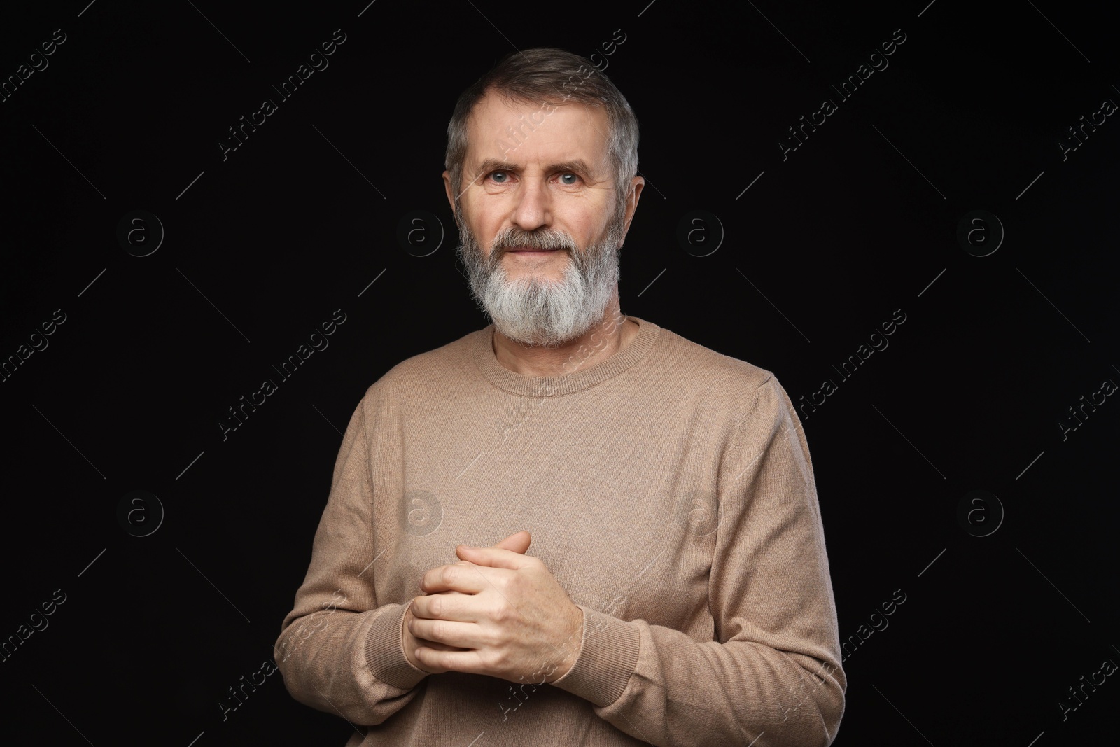 Photo of Portrait of mature man on black background