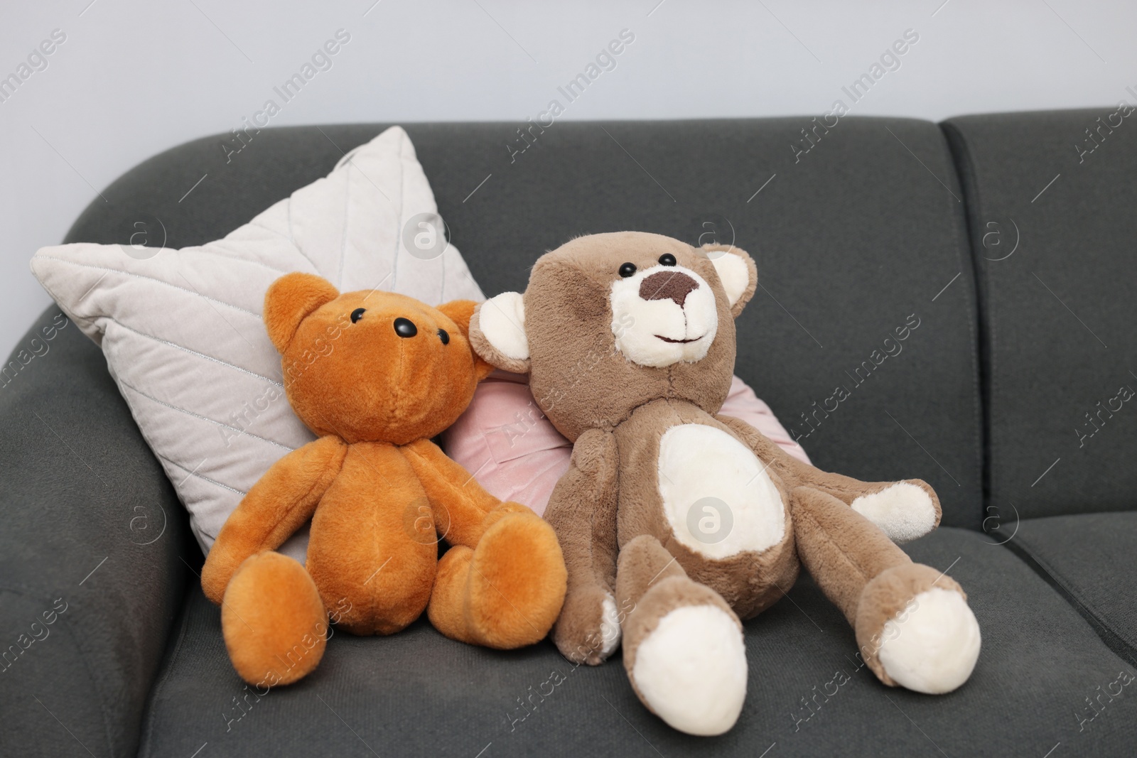 Photo of Teddy bears and pillows on sofa in room