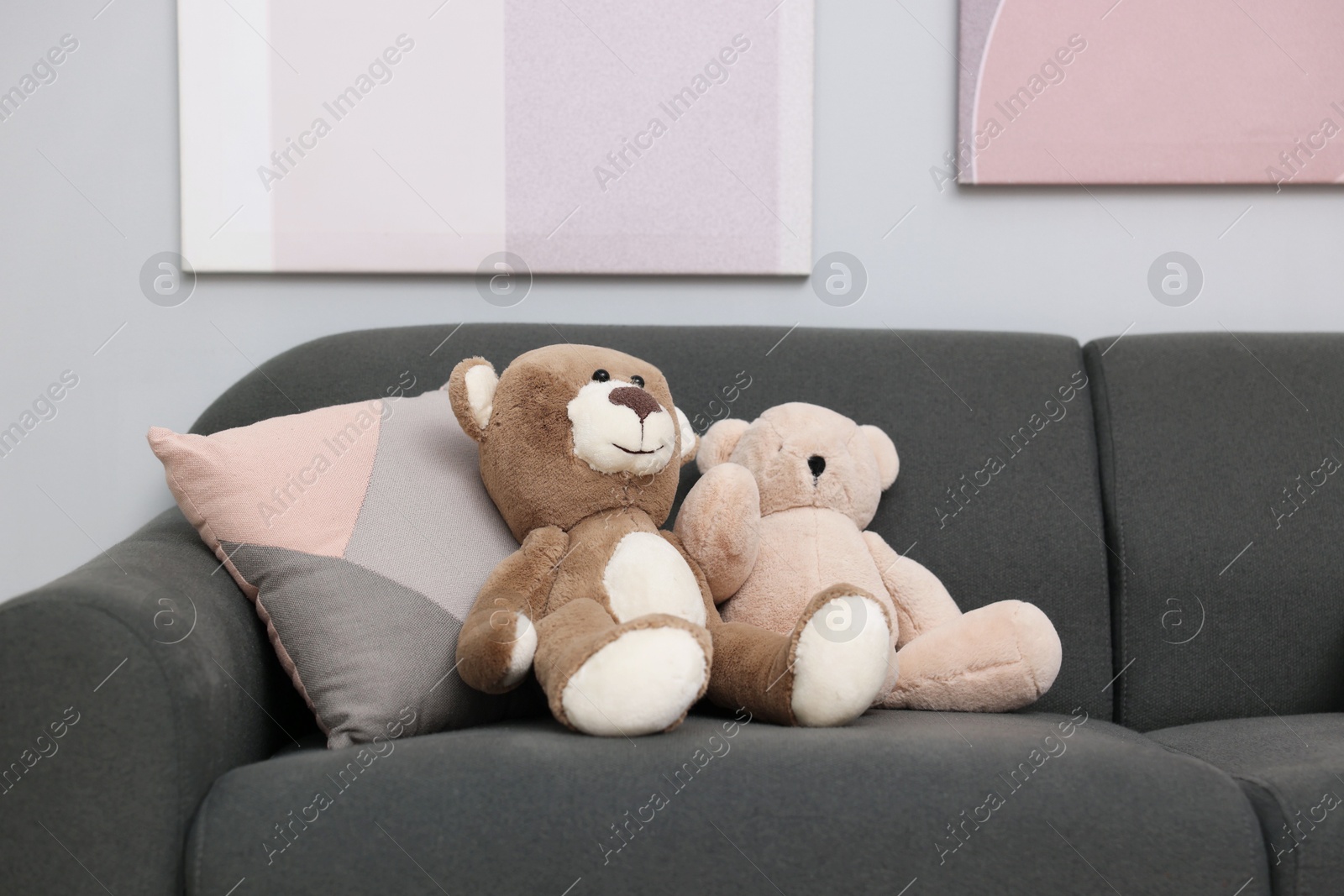 Photo of Teddy bears and pillow on sofa in room