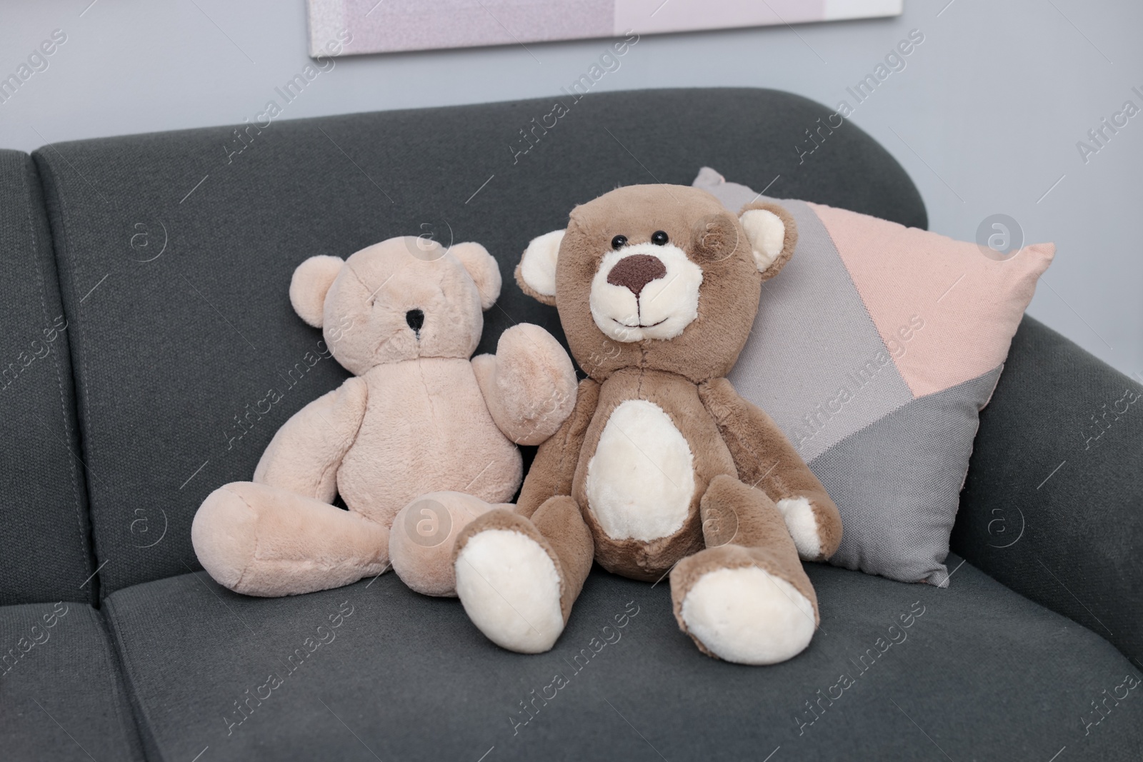 Photo of Teddy bears and pillow on sofa in room