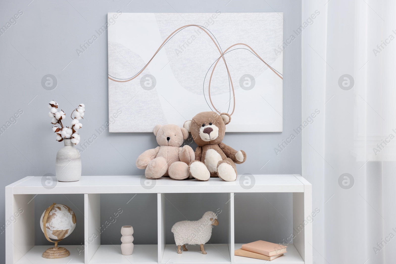 Photo of Teddy bears and decor on shelving unit in room