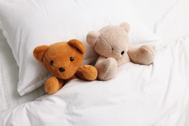 Photo of Two cute plush teddy bears in bed