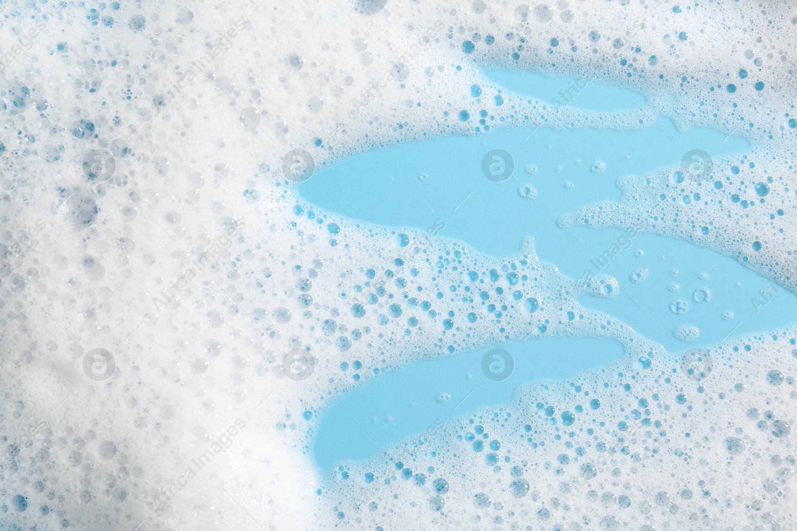 Photo of Detergent foam with bubbles on light blue background, above view