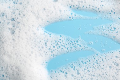 Photo of Detergent foam with bubbles on light blue background, above view