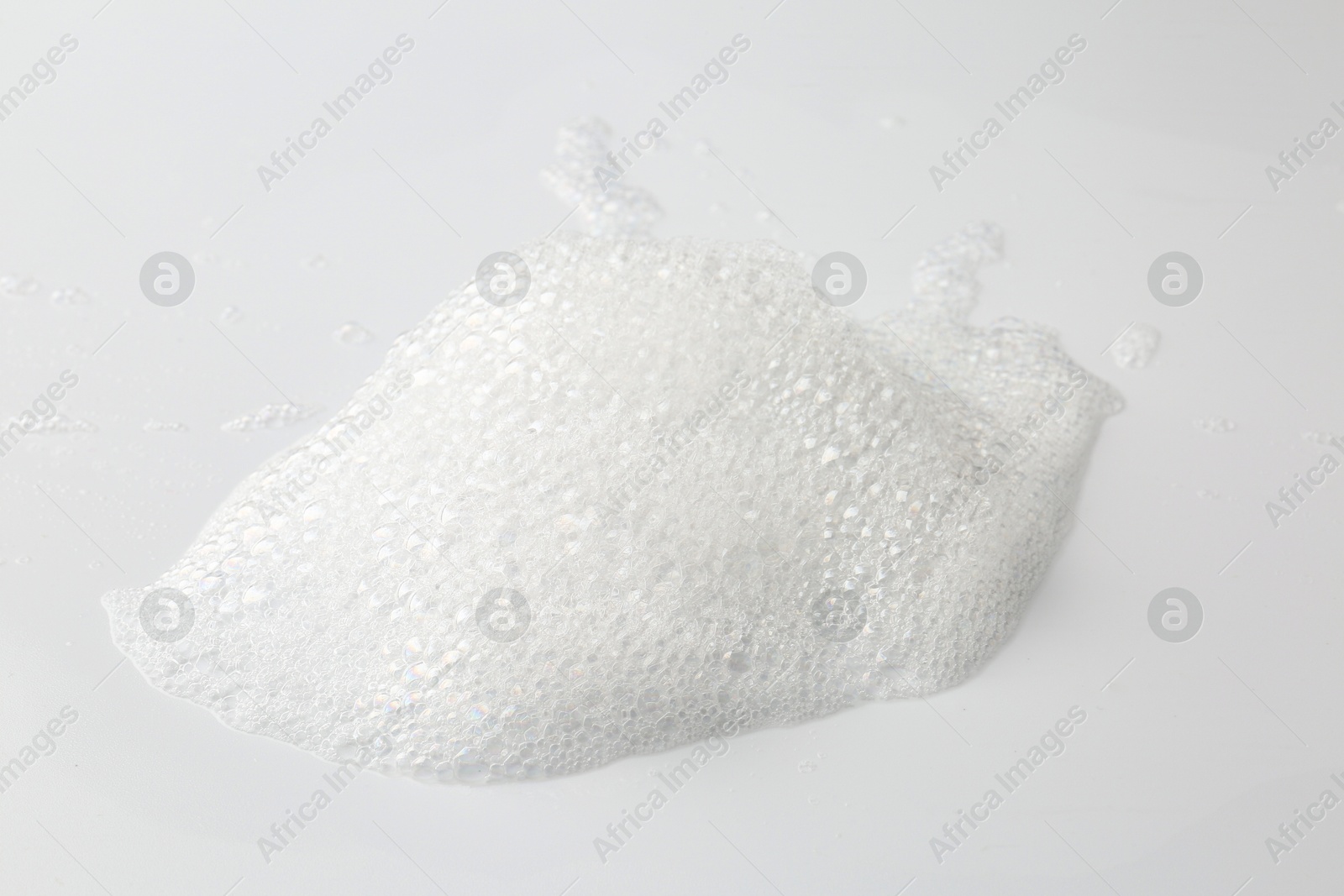 Photo of Detergent foam with bubbles on white background, closeup