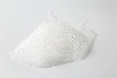 Photo of Detergent foam with bubbles on white background, closeup