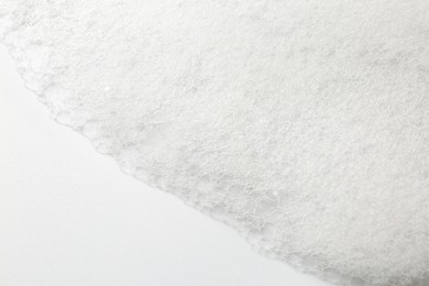 Photo of Detergent foam with bubbles on white background, closeup