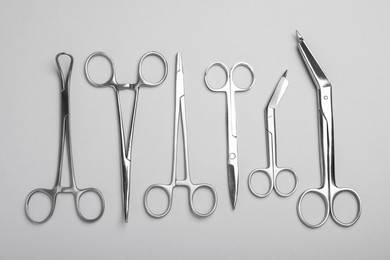 Photo of Different surgical instruments on grey background, flat lay