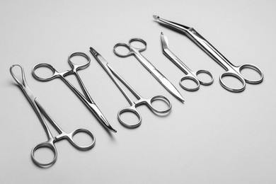 Photo of Different surgical instruments on grey background, closeup