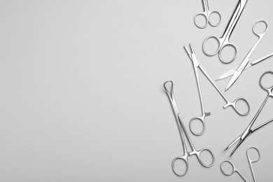 Photo of Different surgical instruments on grey background, flat lay. Space for text