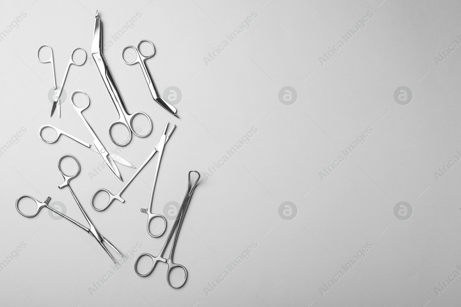 Photo of Different surgical instruments on grey background, flat lay. Space for text