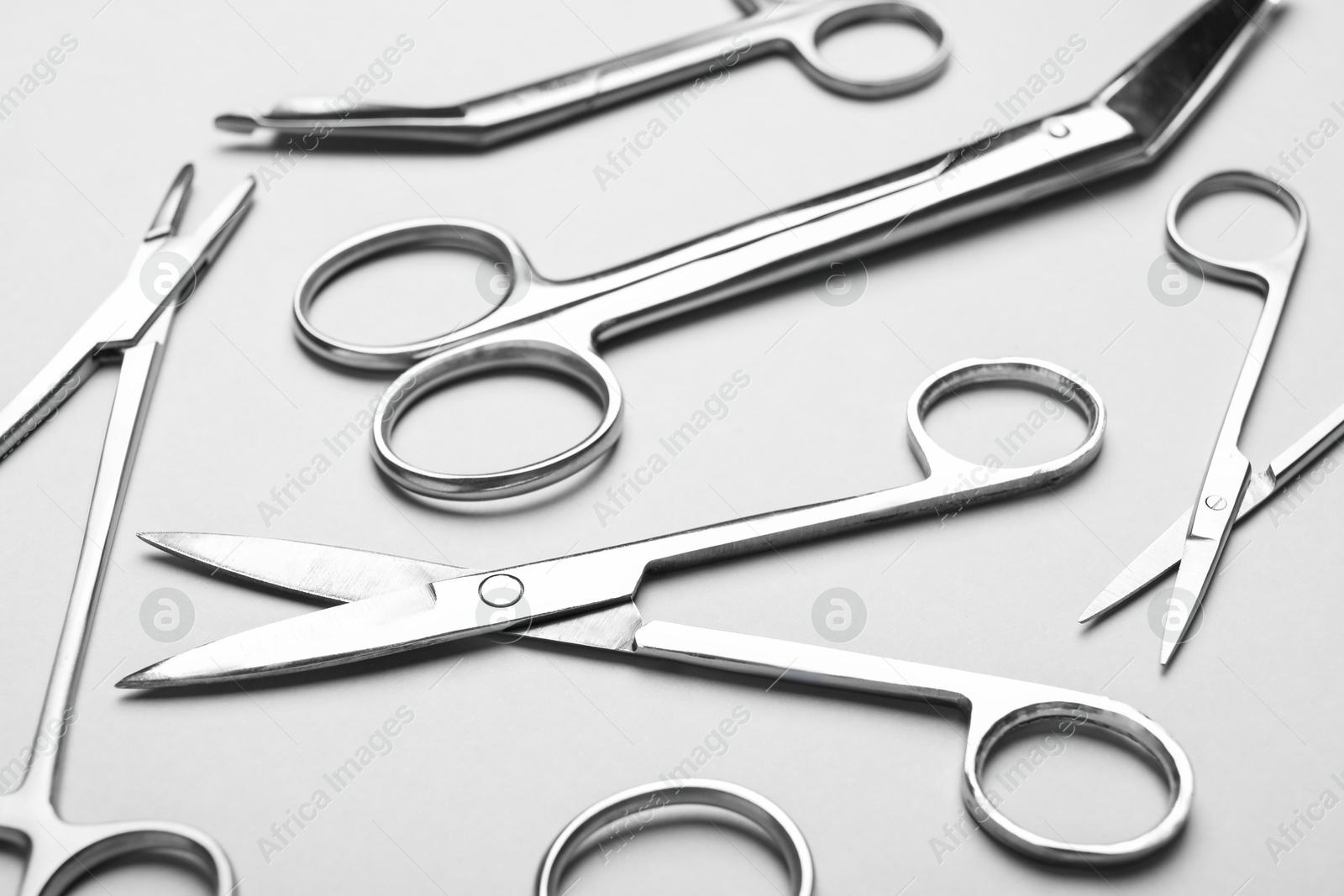 Photo of Different surgical instruments on grey background, closeup