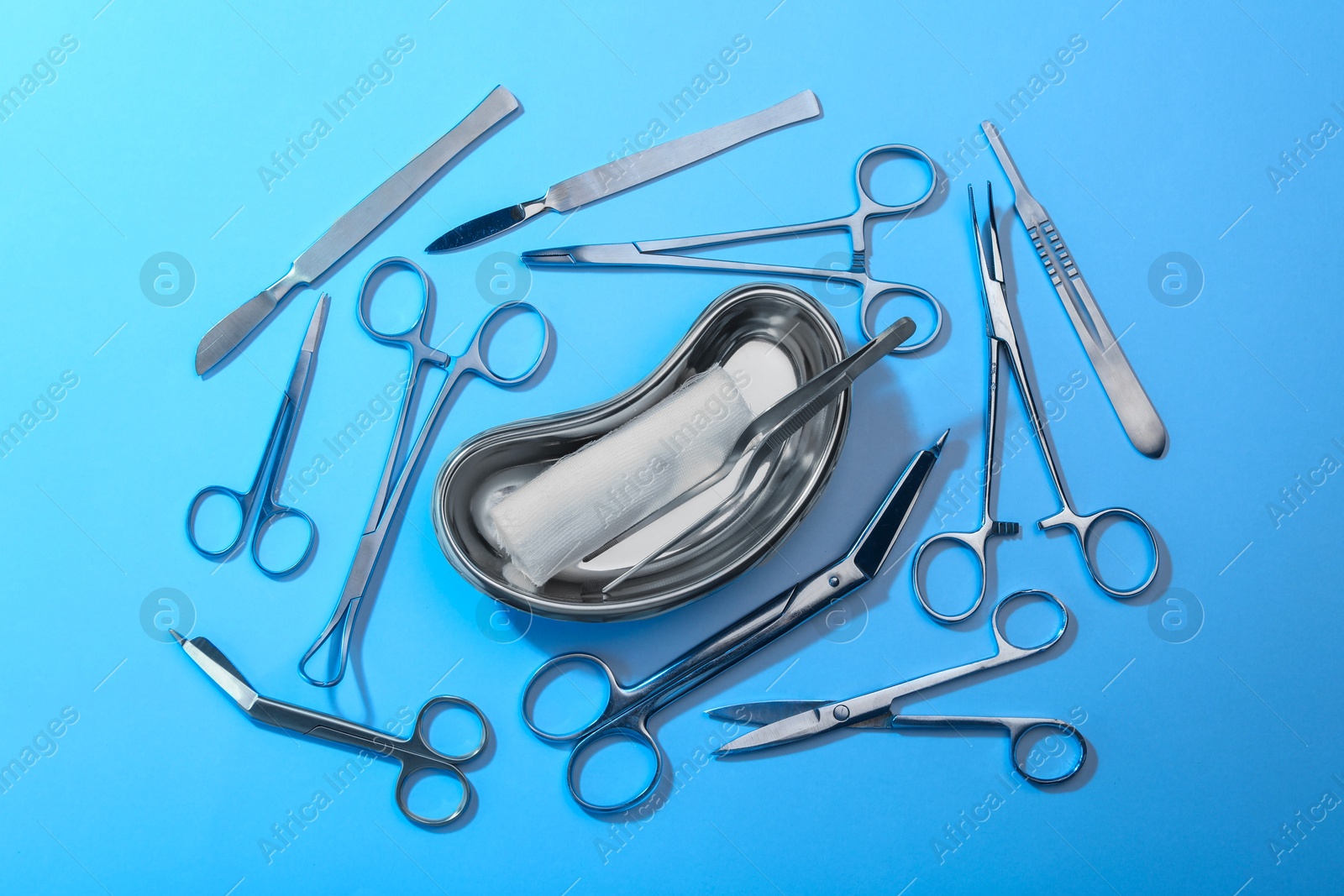 Photo of Different surgical instruments on light blue background, flat lay