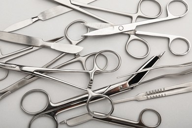 Photo of Different surgical instruments on grey background, flat lay