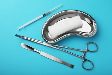 Photo of Different surgical tools on light blue background, flat lay