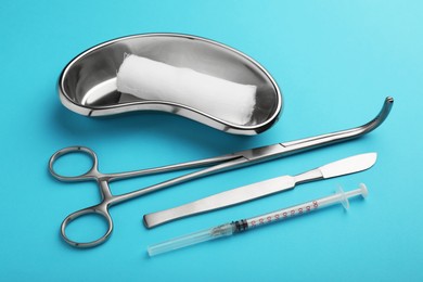 Photo of Different surgical tools on light blue background, closeup