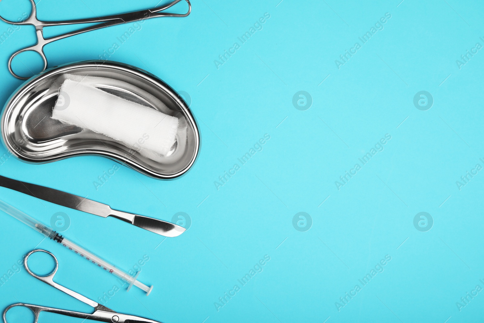 Photo of Different surgical tools on light blue background, flat lay. Space for text