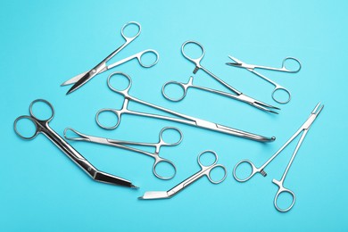 Photo of Different surgical tools on light blue background, flat lay