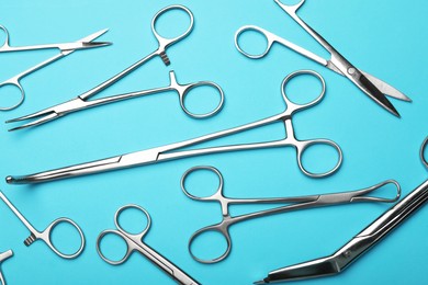 Photo of Different surgical tools on light blue background, flat lay