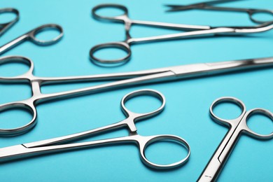 Photo of Different surgical tools on light blue background, closeup