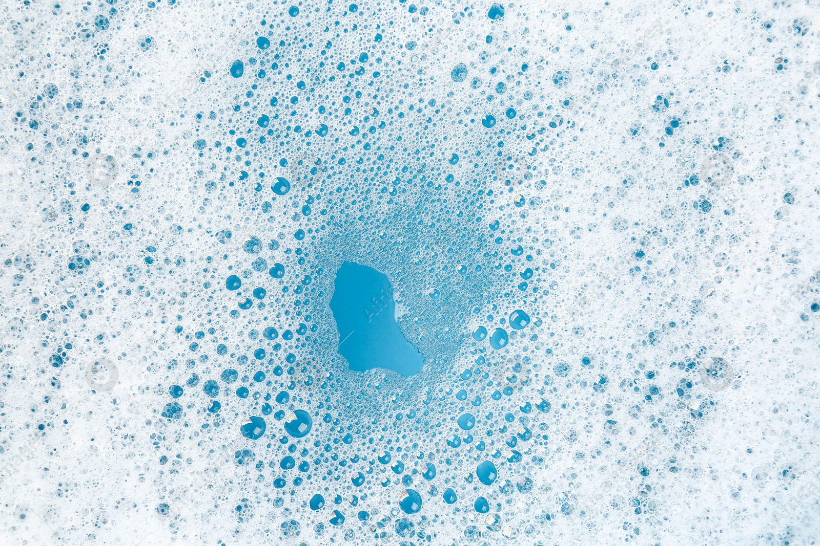 Photo of Detergent foam with bubbles on light blue background, top view