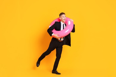 Photo of Businessman with inflatable ring on orange background