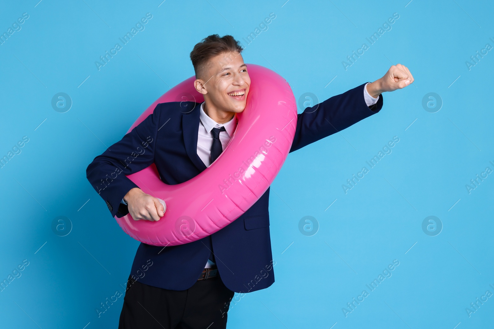 Photo of Businessman with inflatable ring on light blue background