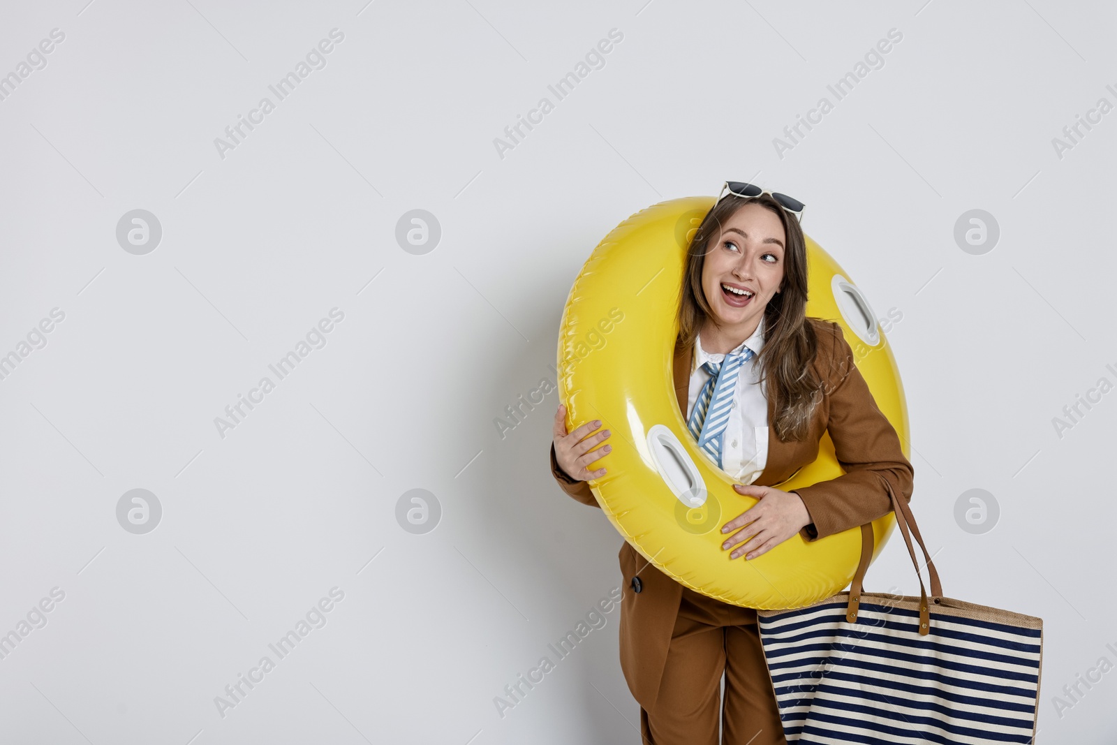 Photo of Businesswoman with inflatable ring, bag and sunglasses on white background, space for text