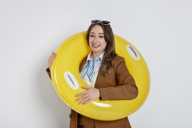 Photo of Businesswoman with inflatable ring and sunglasses on white background