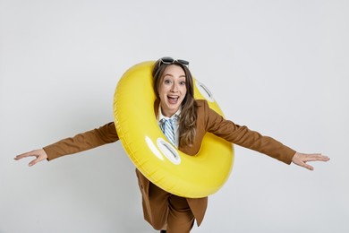 Photo of Businesswoman with inflatable ring and sunglasses on white background